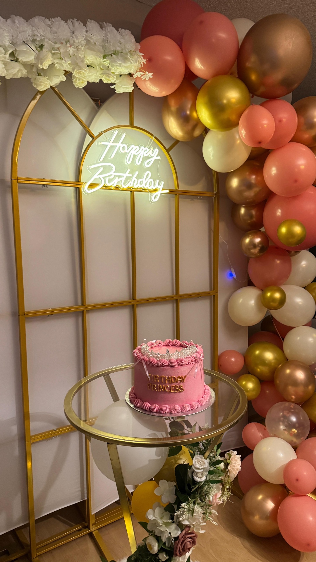 Goldener Bogen mit Neonschrift und rosa Geburtstagstorte
