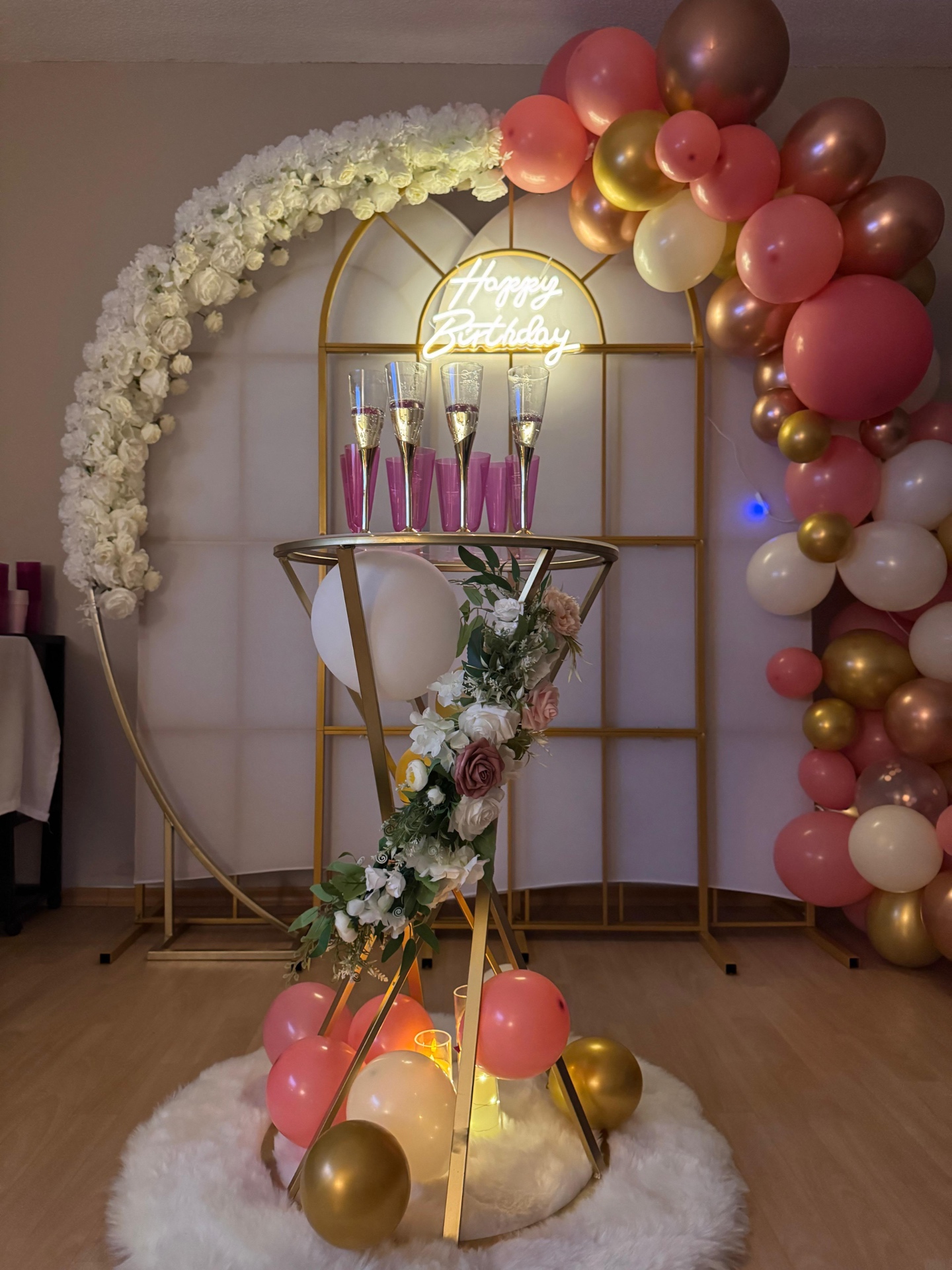 Blütenbogen mit Sektgläsern, Blumendeko und Ballongirlande in Rosé und Gold