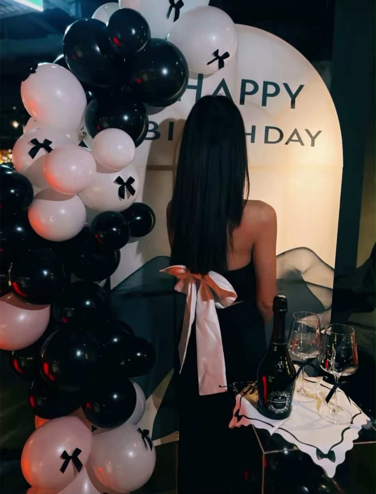 Elegante Geburtstagskulisse in Schwarz-Weiß mit Ballongirlande, Schleifen und Sekt