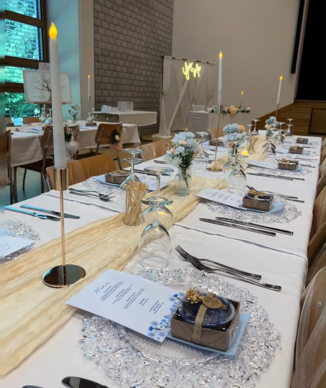 Lange Hochzeitstafel mit Läufer, Kerzen und Gastgeschenken
